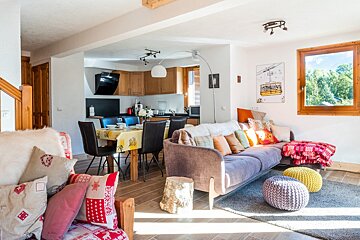 A living room with a couch and chairs and a painting of a ski lift on the wall