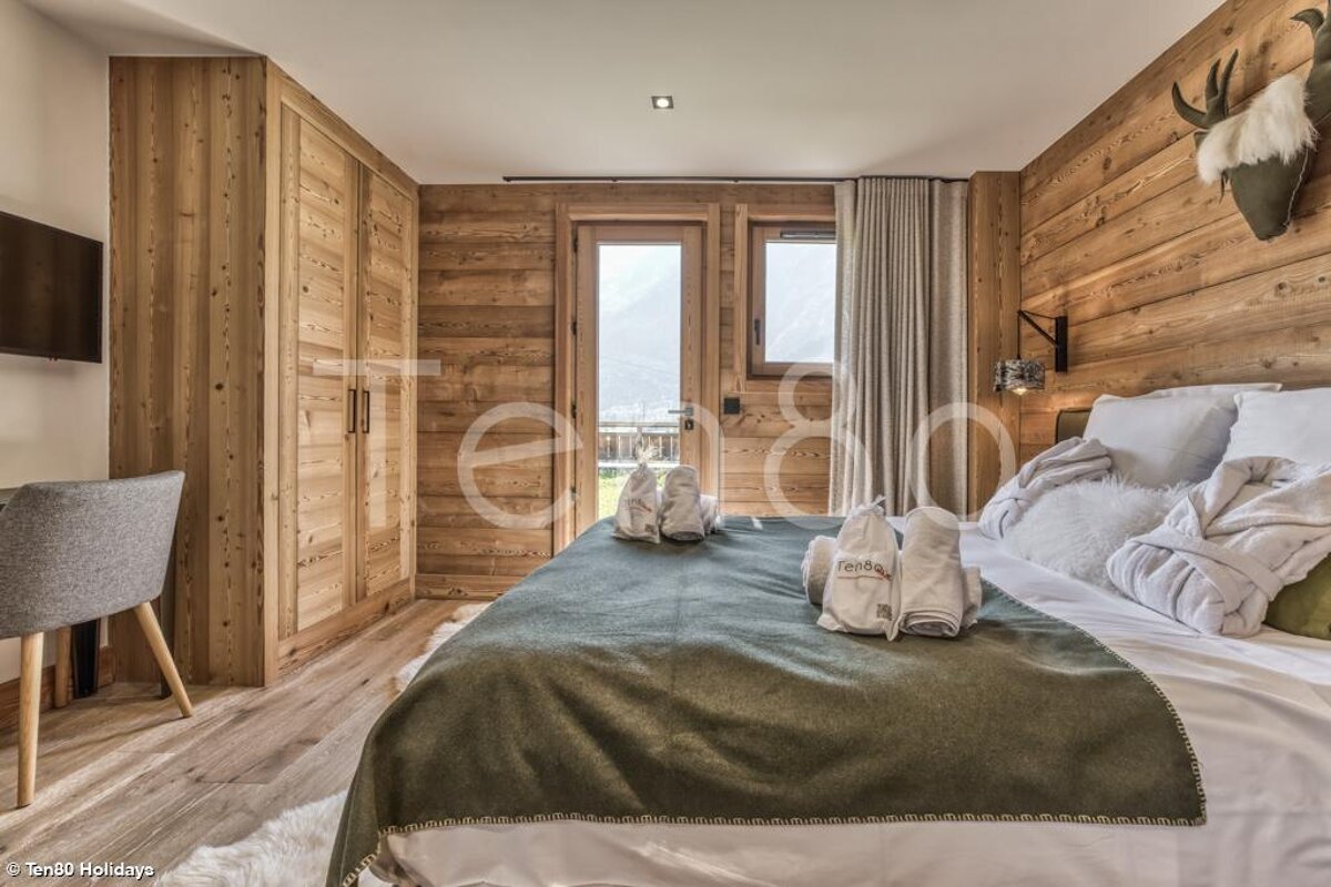 A bedroom with a large bed and a blanket that says towels on it