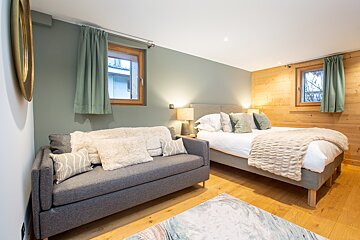 A bedroom with a large bed and a couch