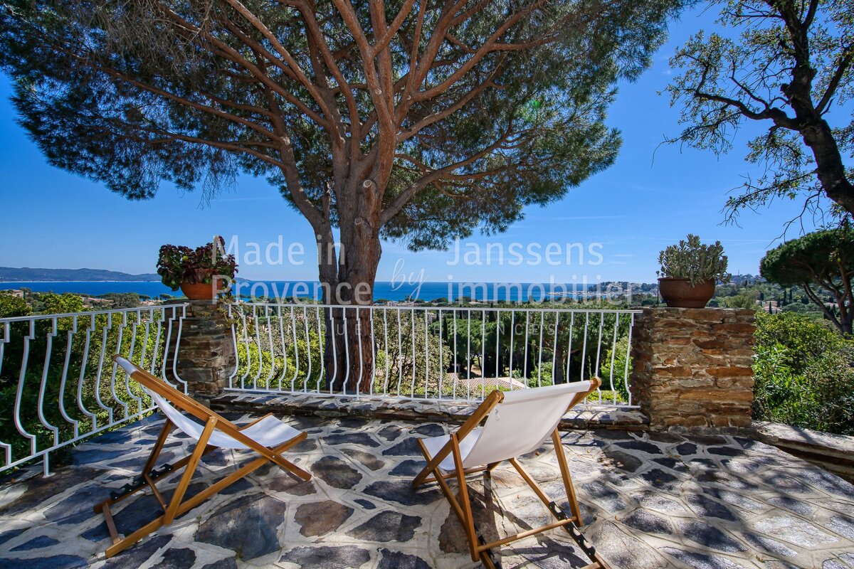 A balcony with chairs and a tree with the words made in janssens provence on it