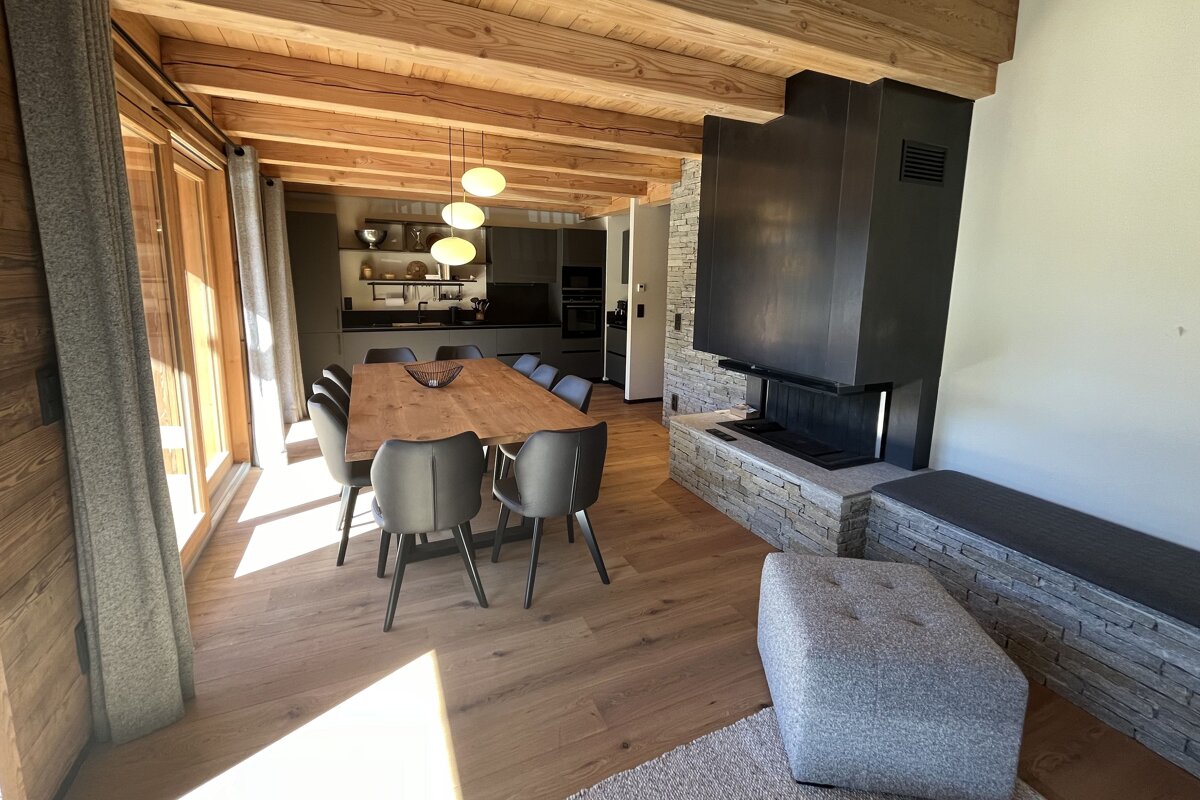 A dining room with a table and chairs and a fireplace