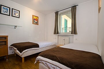 A bedroom with two beds and three pictures on the wall