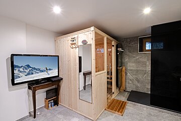 A tv shows a picture of a person skiing in the mountains