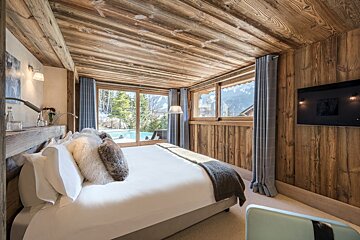 A bedroom with a large bed and a flat screen tv