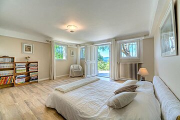 A bedroom with a large bed and bookshelves full of books
