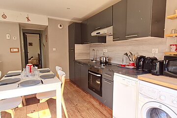 A kitchen with a table and chairs and a washing machine