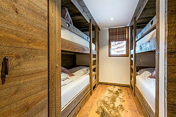 A room with bunk beds and a rug on the floor