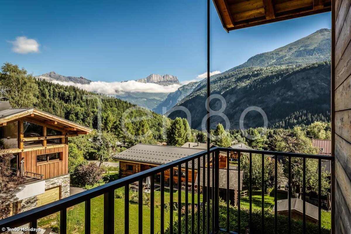 A balcony with a view of the mountains and houses