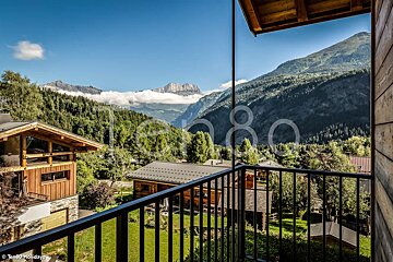 A balcony with a view of the mountains and houses