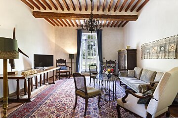 A living room with a couch and chairs and a chandelier