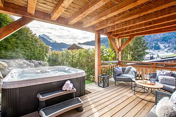 A hot tub on a deck with a view of the mountains