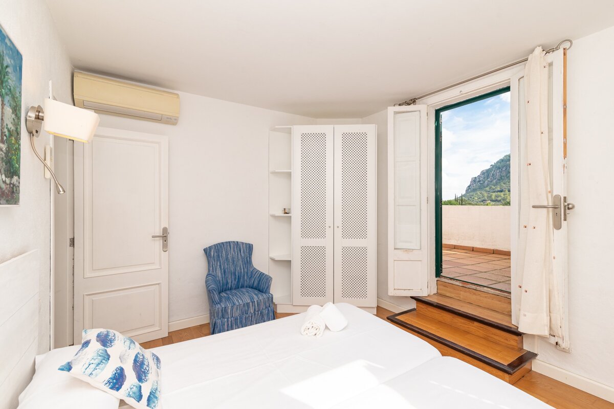 A bedroom with a large bed and a blue chair