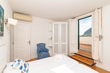 A bedroom with a large bed and a blue chair