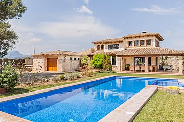 A large house with a large swimming pool in front of it