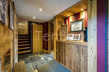 A wooden hallway with a sign on the wall that says