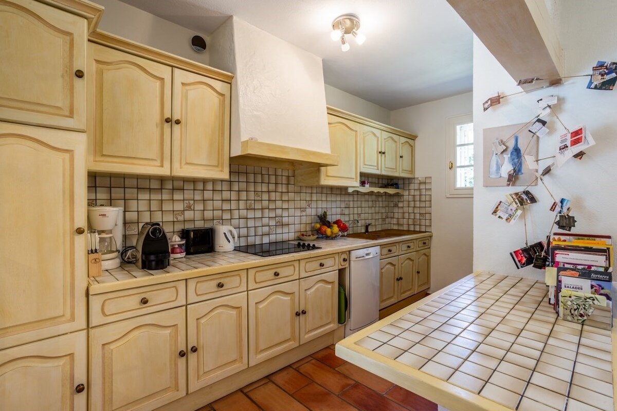 A kitchen with white cabinets and a dishwasher