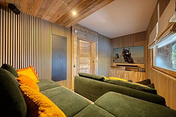 A living room with a green couch and a flat screen tv