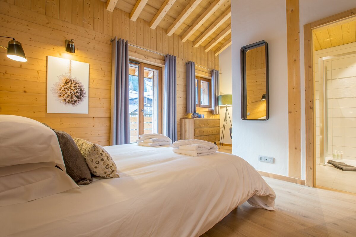 A bedroom with a large bed and a mirror