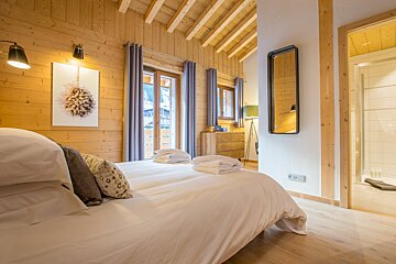 A bedroom with a large bed and a mirror