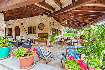 A patio area with rocking chairs and potted plants