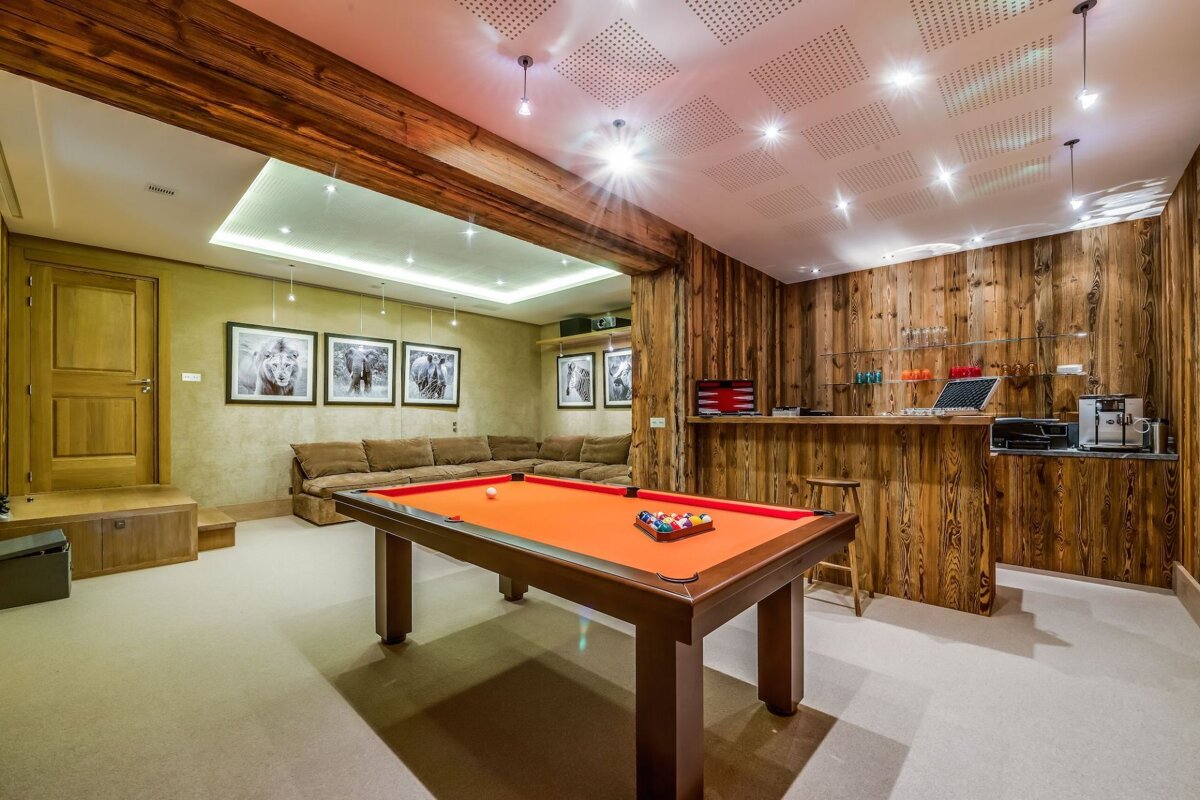 A pool table in a room with pictures on the wall