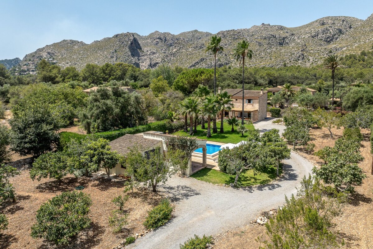 An aerial view of a house with mountains in the background