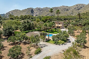 An aerial view of a house with mountains in the background