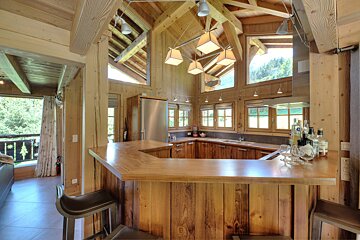 A kitchen with a bar and bottles of liquor on it