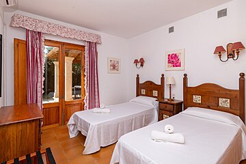 A bedroom with two twin beds and a dresser