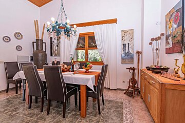 A dining room with a table and chairs and a chandelier