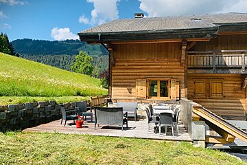 A wooden house with a patio in front of it
