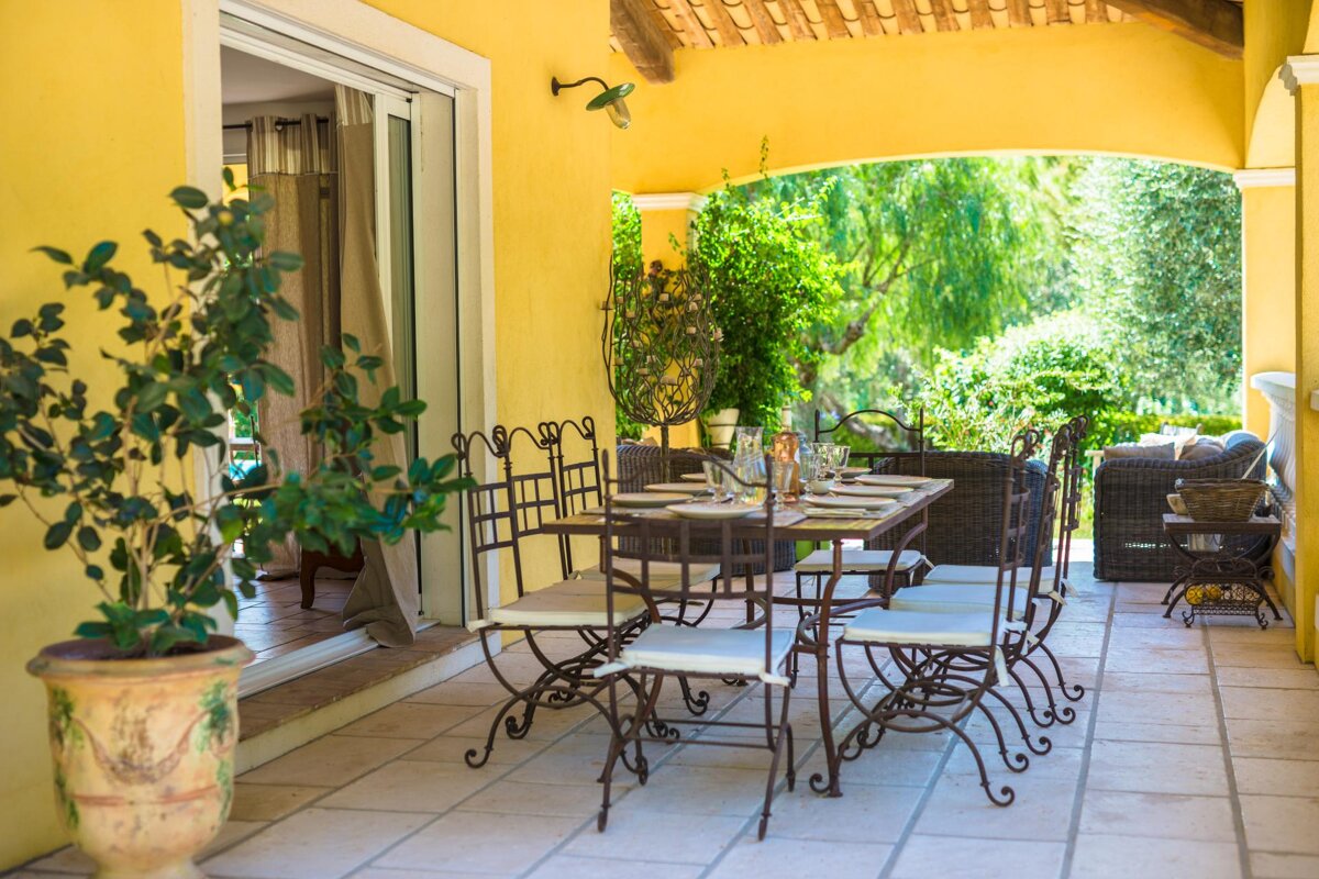 A patio with a table and chairs and a potted plant