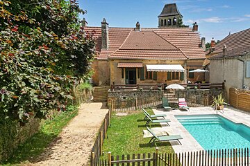 A house with a swimming pool in front of it