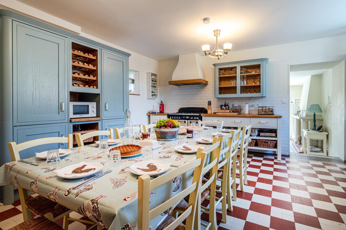 A kitchen with a table and chairs and a checkered floor