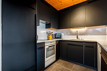 A kitchen with black cabinets and a white stove
