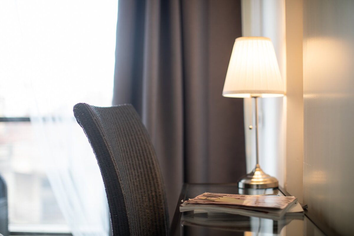 A lamp sits on a desk next to a chair