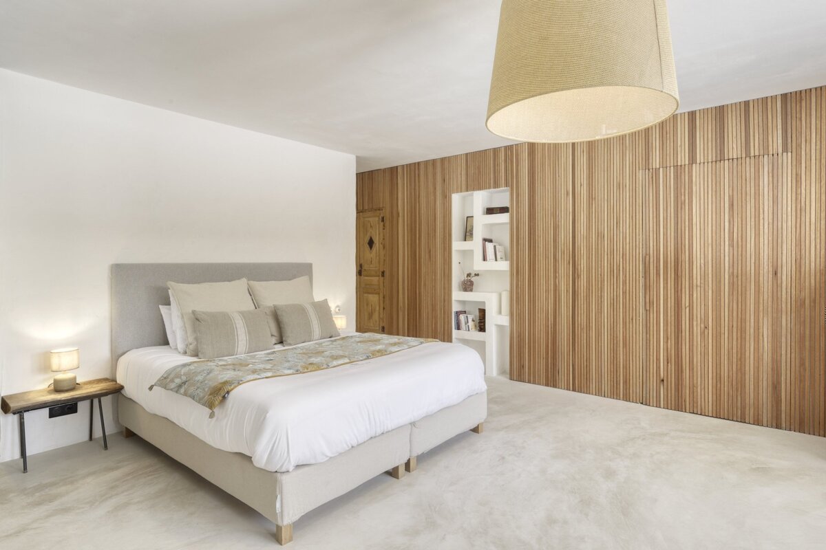 A bedroom with a bed and a wooden wall