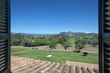 A view of a lush green field with mountains in the background