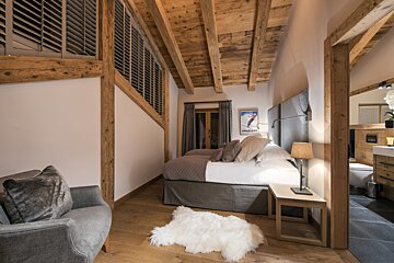 A bedroom with a ski poster on the wall above the bed