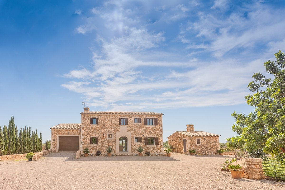 A large stone house with a garage in front of it