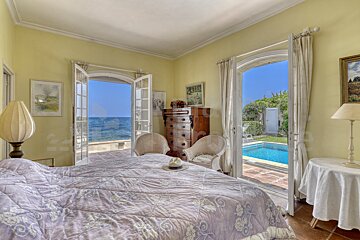 A bedroom with a large bed and a view of the ocean