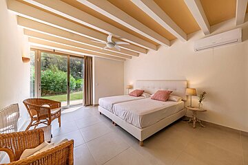 A bedroom with two beds and a ceiling fan