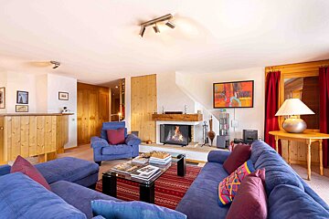 A living room with a blue couch and a fireplace