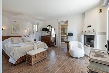 A bedroom with a canopy bed and a fireplace