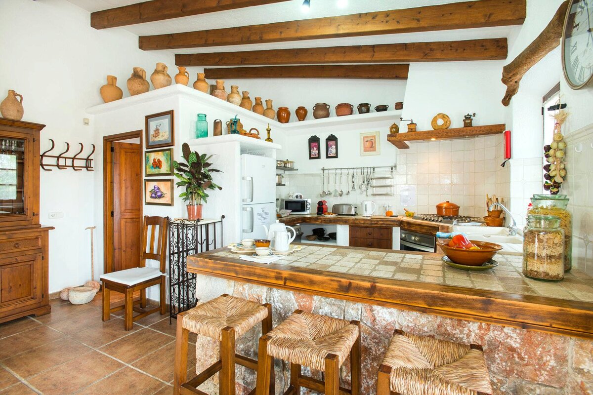 A kitchen with a wooden counter and wicker stools