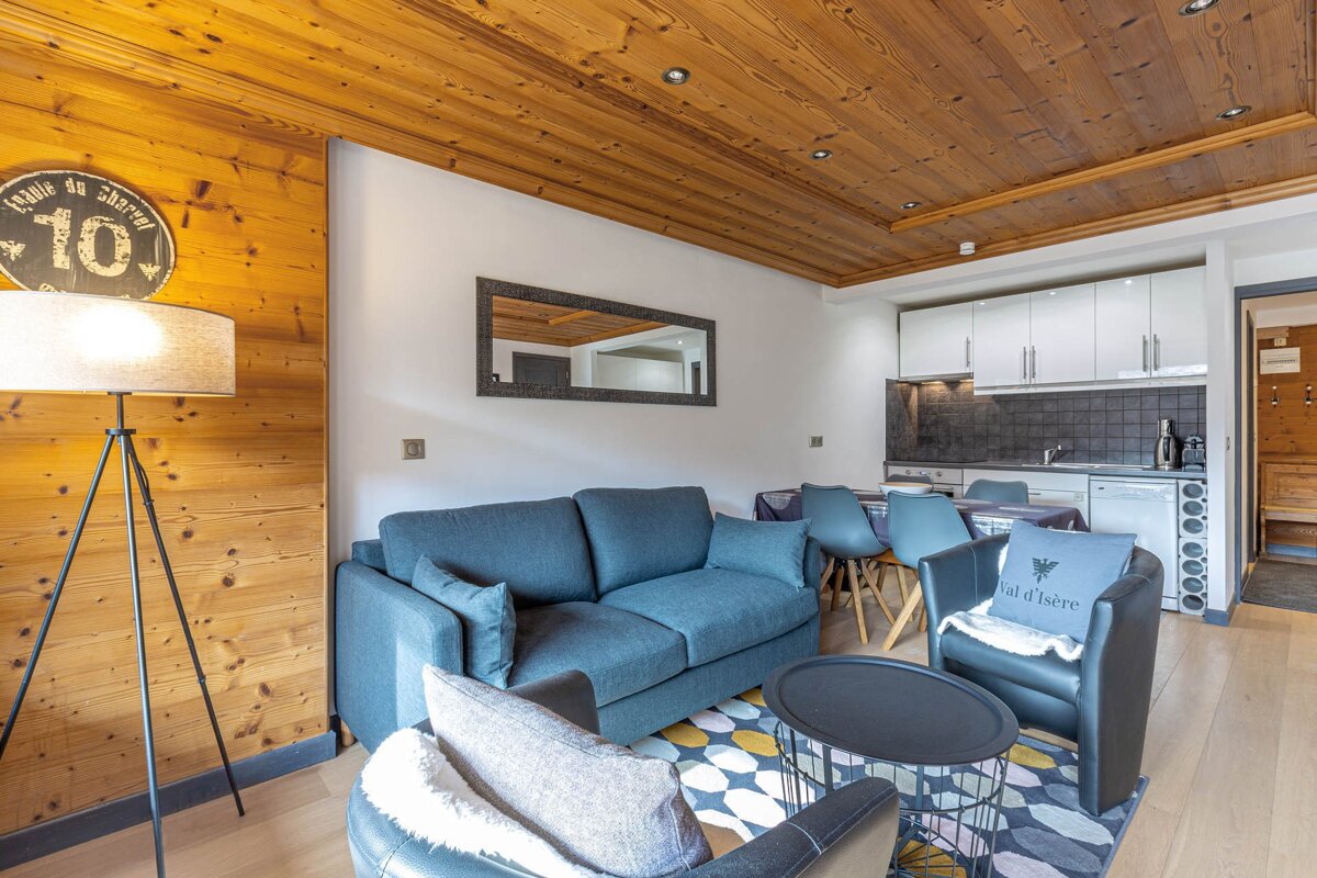 A living room with a couch and a chair with a pillow that says val d' isere