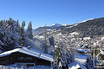 A snowy mountain landscape with a house in the foreground
