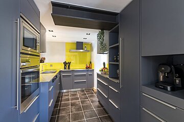 A kitchen with blue cabinets and a black coffee maker
