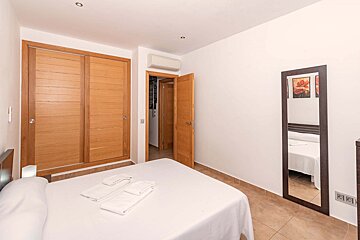 A bedroom with a bed and a large mirror