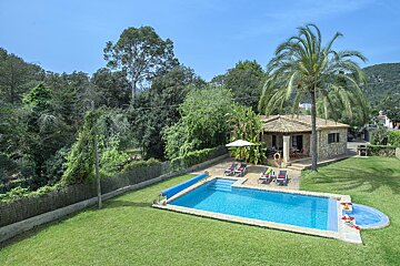 A house with a large swimming pool in front of it